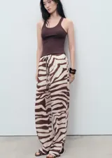 Pantalón fluido de tiro medio con estampado de cebra, diseño recto y largo, cintura elástica con cordón de ajuste y forro interior de algodón.