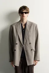 Blazer cruzado regular fit de corte clásico en tono marrón, confeccionado en tejido con motivo de cuadros pequeños, solapas de muesca, bolsillos con solapa en la cadera y botones oscuros a contratono.