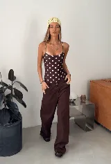 Malla enteriza de escote redondo y breteles finos, con estampado de lunares blancos sobre fondo negro.