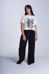 Remera blanca de algodón con estampado de flores de magnolia y texto en negro.