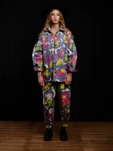 Pantalón de gabardina con estampado floral multicolor, corte carrot fit, tiro medio, estilo carpintero, con botón de metal personalizado, pieza carpintera y parche trasero personalizado.