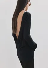 Chaleco de punto fino semitransparente color negro, con diseño recto, cuello redondo y manga larga. Presenta espalda abierta y drapeada, sin cierre.