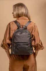 Mochila urbana de diseño combinado, confeccionada en tela resistente con bolsillo frontal y detalles en cuero sintético. Cuenta con compartimento principal con cierre y correas ajustables.