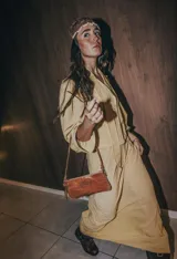 Mini cartera de cuero color crudo con correa larga extraíble y bolsillo interno con cierre.