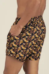 Short de baño con estampado floral en tonos marrones y amarillos, con cintura elástica ajustable con cordón.