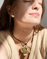 Aros tipo caravanas de diseño orgánico con forma irregular y textura rugosa, con acabado metálico brillante.