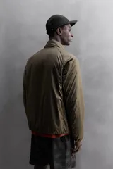 Cazadora deportiva acolchada color verde oscuro, con cuello alto y cierre frontal con cremallera. Cuenta con bolsillos laterales con cremallera oculta y un bolsillo interior.