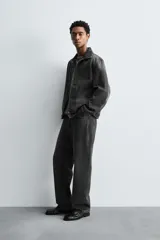 Jeans straight fit de denim de algodón color negro con efecto lavado. Cuentan con cinco bolsillos y cierre frontal de botonadura.