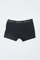 Boxer negro con elástico en la cintura con la inscripción "Uniform" repetida.