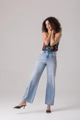 Pantalón de jean celeste de tiro alto y corte recto, con apliques de strass plateados en los laterales.