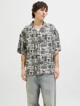 Camisa de manga corta con cuello resort y corte amplio. Presenta un estampado integral en tonos blanco y negro con motivos botánicos y marinos. Confeccionada en tejido liviano de viscosa y lino.