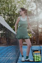 Falda azul de lycra con short incorporado y volado. Tiene bolsillo para pelotas de tenis, elástico rayado en los laterales y logo en la pretina.