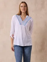 Blusa amarilla de manga 3/4 con escote en V y bordado multicolor. Largo de manga regulable con presilla y botón. Marca Ruby Rd.