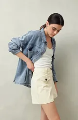 Short de tiro alto color beige, con bolsillos delanteros con solapa y botones a la vista.