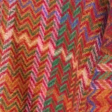 Poncho abierto con diseño de tejido en zigzag multicolor, con flecos en el ruedo.