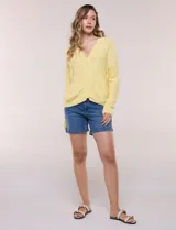 Cardigan blanco de punto liviano y texturado, de corte holgado y diseño casual. Cuenta con escote en V pronunciado, abotonadura frontal, mangas largas con hombros caídos y bolsillos delanteros tipo parche.