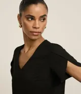 Blusa color beige de poliéster con efecto arrugado (airflow), escote en pico y mangas cortas tulipán (cruzadas).