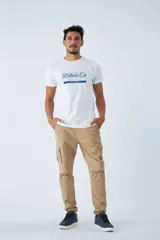 Pantalón cargo de hombre con fit slim, confeccionado en una mezcla de algodón y elastano. Presenta cierre de cremallera y botón, bolsillos laterales tipo cargo, pasa cinto y terminación con puños elásticos en los tobillos.