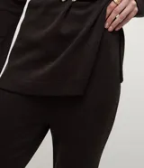 Pantalón de corte flare confeccionado en tejido piquet, con cintura alta y ajuste ceñido en caderas y muslos que se ensancha suavemente desde la rodilla.