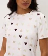 Blusa de pijama de color blanco con estampado de corazones en tonos marrones y beige, cuello redondo y mangas cortas.