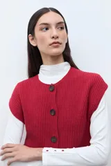 Chaleco tejido de punto acanalado en color rojo, con cuello redondo y cierre frontal de botones oscuros.