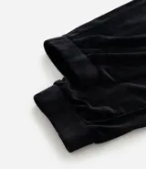 Pantalón jogger de plush color negro, con cintura elástica, bolsillos laterales y puños ajustados en los tobillos.