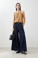 Top tostado sin mangas con cuello halter y brillos.