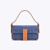 Cartera tipo baguette de tela denim azul con detalles en cuero sintético color suela. Presenta una solapa frontal con cierre magnético y una correa de hombro fija.