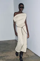 Top de tejido punto color marrón oscuro, con escote asimétrico tipo *one-shoulder* y drapeado frontal.