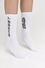 Pack de dos pares de medias blancas de caña alta, con base de toalla y logo de la marca en negro.