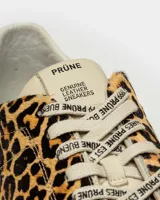 Zapatillas bajas con estampado animal print, cordones con letras estampadas, suela de goma color crema y refuerzo de cuero en el talón.