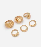 Kit de seis anillos metálicos con baño dorado, de diseños variados que incluyen modelos texturizados, tipo bold y con formas orgánicas.
