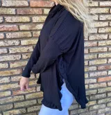 Polerón blanco de morley con cuello alto y volados en ruedo y puños.