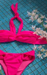 Conjunto de bikini blanco con corpiño bandeau con tiras para atar al cuello y bombacha con detalle de frunces en los laterales.