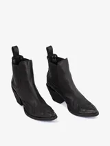 Bota corta estilo cowboy negra, de cuero, con punta afilada y taco ancho y bajo. Presenta bordados tonales en la caña y en la puntera.