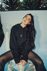 Hoodie blanco de corte oversize con capucha y diseño estampado en la espalda con letras negras.