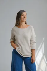 Sweater de punto color beige, con escote a la base y mangas largas con puños doblados. Diseño holgado y versátil.