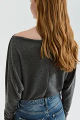 Top de punto fino en color gris, con escote bote y mangas largas tipo dolman. Presenta un corte holgado y puños ajustados.