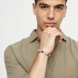 Pulsera elástica con cuentas de aleación de metales bañadas en plata y cristal de murano negro.