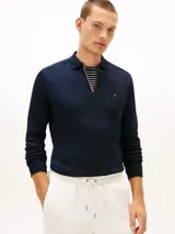 Chomba de manga larga Tommy Hilfiger de color azul marino, confeccionada en algodón con acabado Liquid Touch. Presenta cuello clásico, cierre frontal con cremallera corta y detalles tricolores en el interior de la abertura. Cuenta con puños acanalados y el logo bordado de la marca en el pecho.