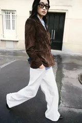 Blazer de ante color marrón, con cuello solapa, hombreras, manga larga y cierre frontal cruzado con botones. Cuenta con bolsillos delanteros de doble vivo.