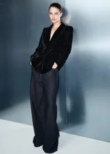 Blazer de terciopelo negro con cuello de solapa, cierre cruzado con botones, bolsillos con solapa en la parte frontal y mangas largas.