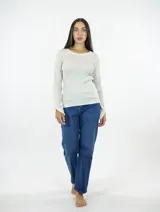 Buzo de punto fino en color beige, con cuello redondo, mangas largas y puños con aberturas laterales.