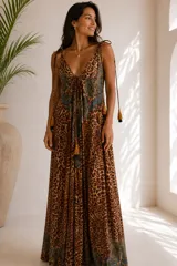 Vestido largo de corte fluido, con estampado animal print combinado con detalles paisley en tonos turquesa. Presenta escote en V con lazo ajustable y tiras finas regulables en los hombros con terminación de borlas.