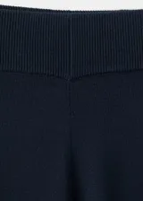 Pantalón azul marino de tiro medio, corte ancho y recto, con pequeñas aberturas en los bajos.