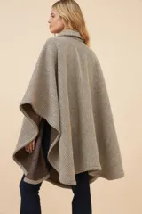 Poncho de lana fina con diseño de rayas diagonales, cuello camisero, cartera con botones a presión y bolsillo ojal en el pecho.