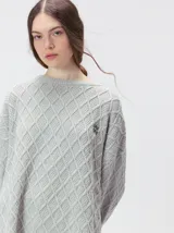 Sweater de cuello redondo con diseño de tejido en relieve de rombos, manga larga y calce holgado. Presenta logo bordado en el pecho y aberturas laterales en el ruedo.