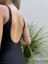 Malla enteriza de color negro con escote en V y corte a la cintura.