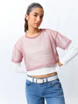 Top cropped de manga corta, color rosado, de tejido símil transparente con sutil brillo de fibras metálicas.
