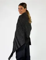 Pashmina de punto color beige con bordados sutiles y flecos largos en los bordes.
